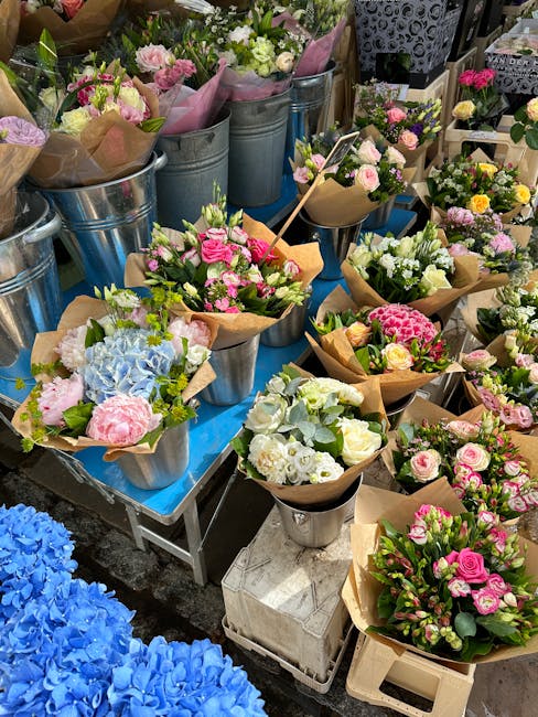 An assortment of fresh flower bouquets displayed on a table at floristforesthill.co.uk, featuring pastel pink roses, white and pale green hydrangeas, and pink and white carnations wrapped in brown cra