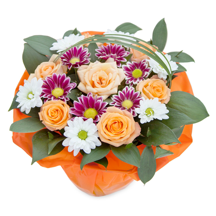 Presiding over this Forest Hill-inspired bouquet is a superb blend of classic design and joyful contemporary flair. Centered amid the display are several peach and orange roses, petals tightly layered yet unfurling gracefully, their subtle gradations of colour reminiscent of early spring sunrises near Sydenham Woods. These roses are flanked by an array of chrysanthemums: pure white, daisy-like blooms with luminous green hearts, paired with denser magenta and violet flowers-each petal articulated to add maximum texture and depth. Abundant, dark green foliage, possibly ruscus or a similar broadleaf, weaves a dense background, giving structure and a luxuriant feel not unlike Forest Hill's leafy high roads. Arcing elegantly overhead, a slender, vivid green loop of decorative grass introduces movement and a hint of whimsy. At the base, the bouquet is expertly gathered in a vibrant orange tissue wrap, echoing the warmth of the roses and tying the presentation together with a cohesive, cheerful touch. Ideal for marking a special moment in Forest Hill-be it an anniversary, birthday, or heartfelt thank you-this arrangement is a testament to skilled craftsmanship and the natural beauty that thrives at the heart of this South London community.